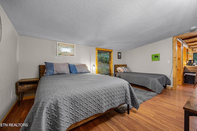 bedroom featuring a textured ceiling and wood finished floors