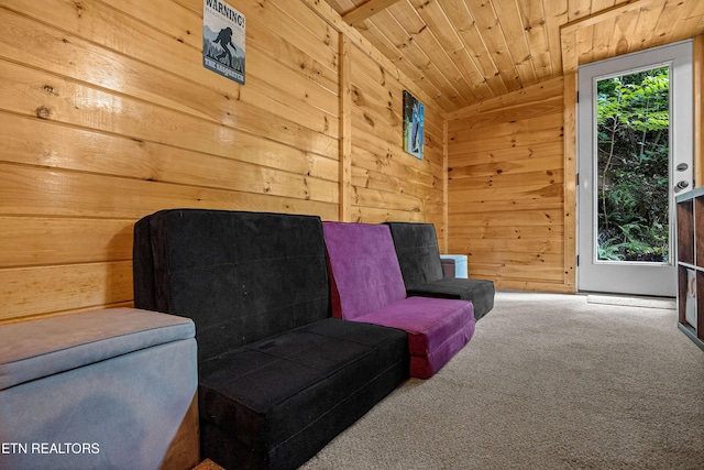 living area featuring carpet floors, wooden ceiling, and wooden walls