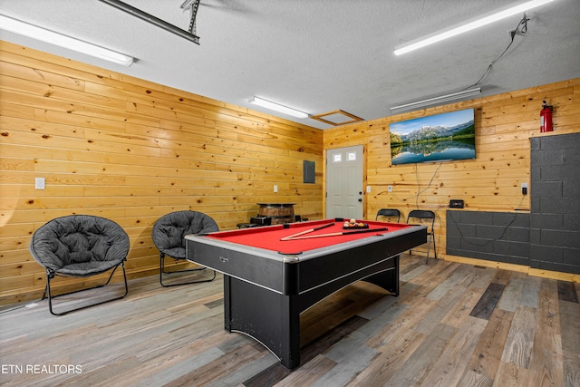 recreation room featuring wood walls, billiards, a textured ceiling, and wood finished floors