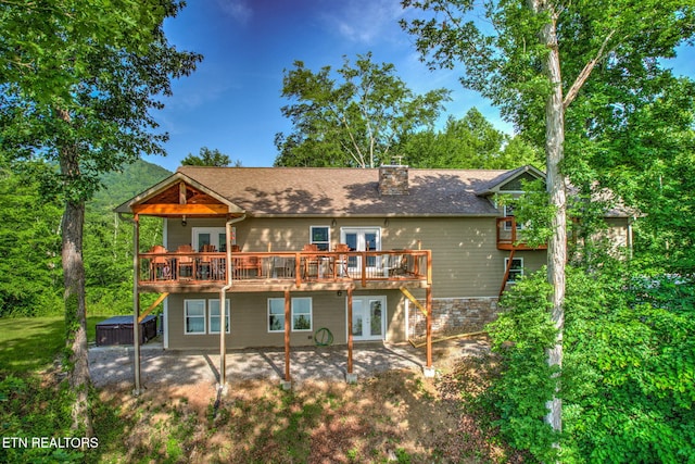 back of property with a patio area, a chimney, a deck, and french doors