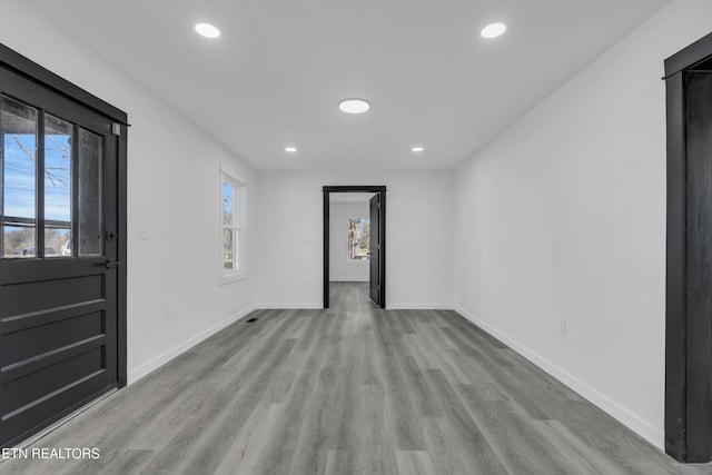 spare room featuring recessed lighting, wood finished floors, and baseboards