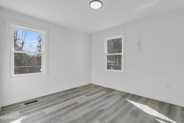 spare room featuring baseboards, visible vents, and a wealth of natural light