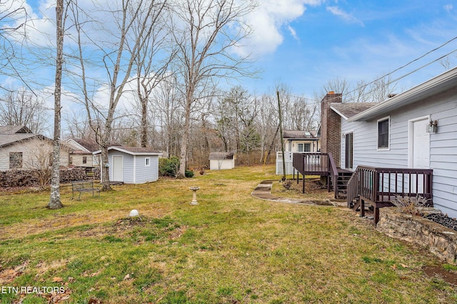 view of yard with an outdoor structure, a deck, and a storage unit