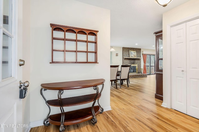 dining room featuring light wood-style floors, a fireplace, and baseboards