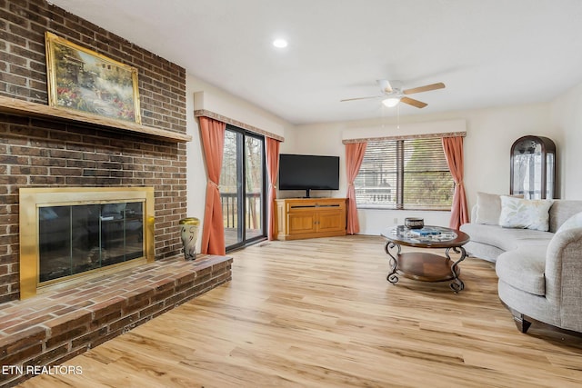 living area with a brick fireplace, wood finished floors, a ceiling fan, and recessed lighting