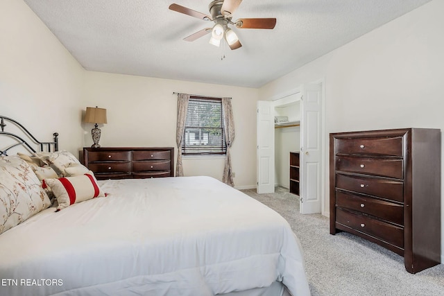 carpeted bedroom featuring baseboards, a ceiling fan, and a textured ceiling