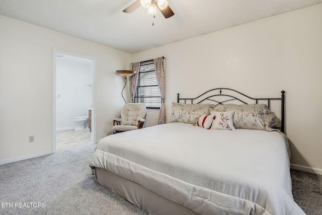 carpeted bedroom with ensuite bath, baseboards, and ceiling fan