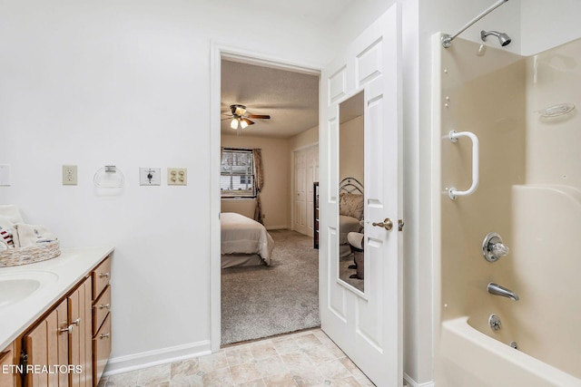 ensuite bathroom featuring ensuite bathroom, a ceiling fan, bathing tub / shower combination, vanity, and baseboards