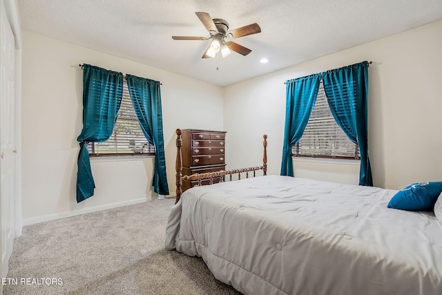 carpeted bedroom featuring a textured ceiling, recessed lighting, a ceiling fan, and baseboards