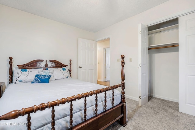 bedroom featuring light carpet, a closet, a textured ceiling, and baseboards