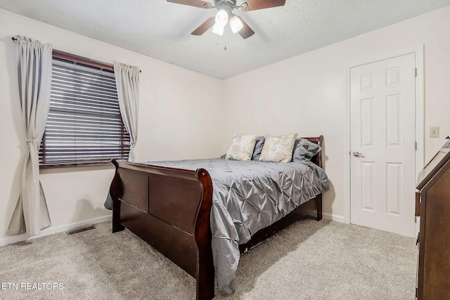 bedroom with carpet floors, visible vents, ceiling fan, a textured ceiling, and baseboards