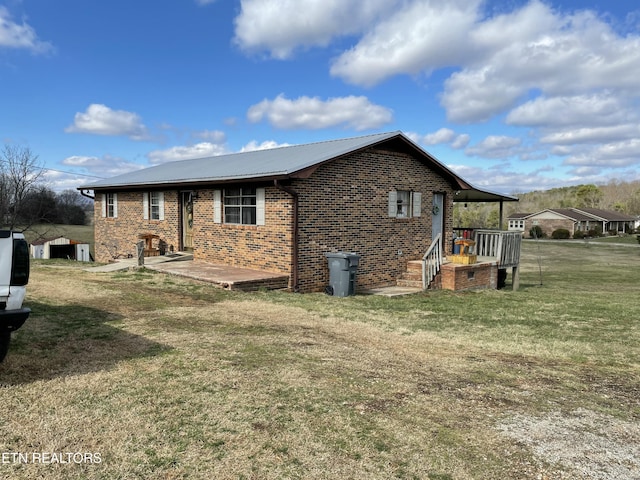 view of property exterior featuring metal roof, a yard, and brick siding