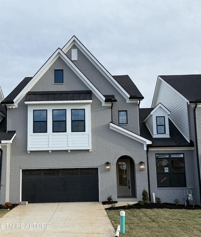 view of front facade featuring metal roof, a standing seam roof, concrete driveway, and a front yard