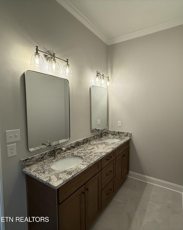 full bath featuring double vanity, crown molding, baseboards, and a sink