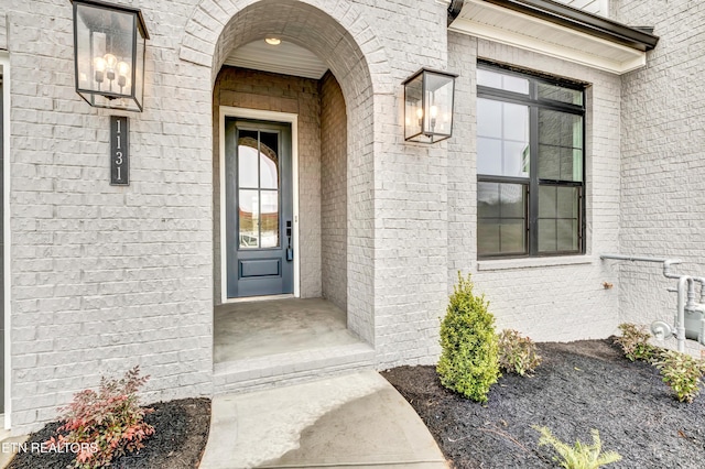 view of exterior entry with brick siding