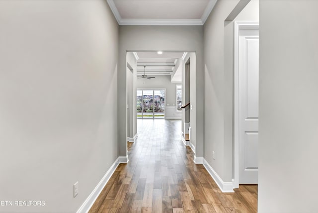 hall featuring crown molding, wood finished floors, and baseboards