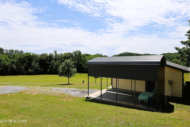 view of grassy yard with a carport and driveway