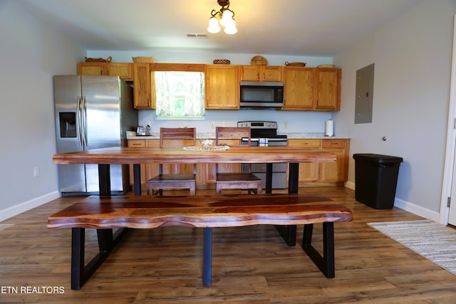 kitchen featuring appliances with stainless steel finishes, electric panel, baseboards, and dark wood-type flooring