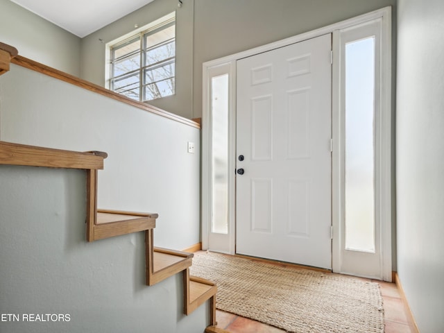 foyer with stairway and baseboards