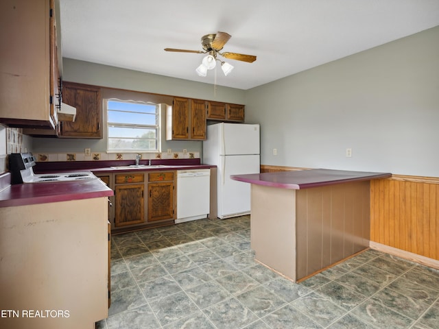 kitchen featuring a ceiling fan, a sink, dark countertops, ventilation hood, and white appliances