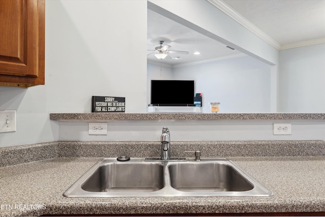 kitchen featuring light countertops, ornamental molding, brown cabinetry, a ceiling fan, and a sink