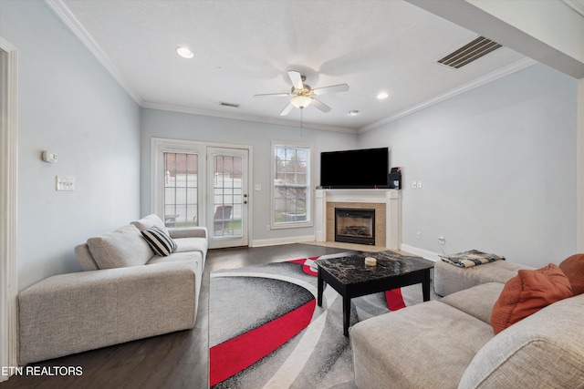 living room with crown molding, visible vents, a ceiling fan, wood finished floors, and baseboards