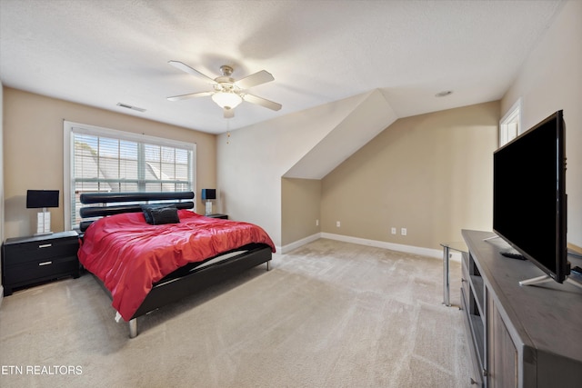 bedroom featuring a textured ceiling, light colored carpet, a ceiling fan, baseboards, and visible vents