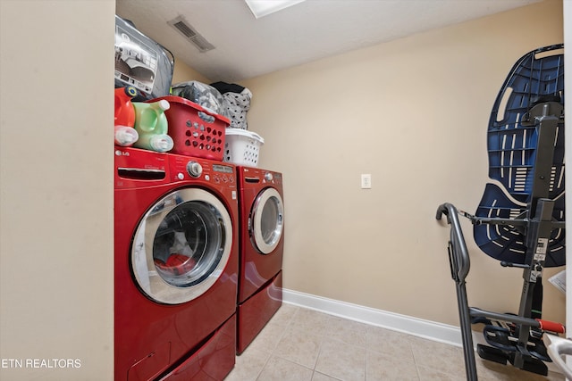 laundry room featuring washer and clothes dryer, visible vents, laundry area, baseboards, and tile patterned floors