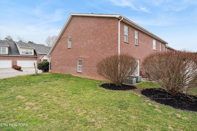 view of home's exterior featuring central AC, brick siding, and a lawn