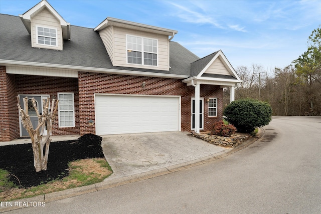 view of front of property with a garage, concrete driveway, brick siding, and a shingled roof