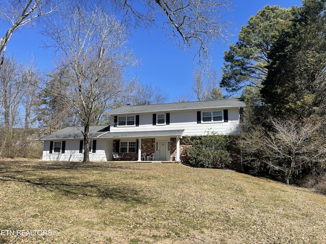 traditional-style home with covered porch, a front lawn, and brick siding