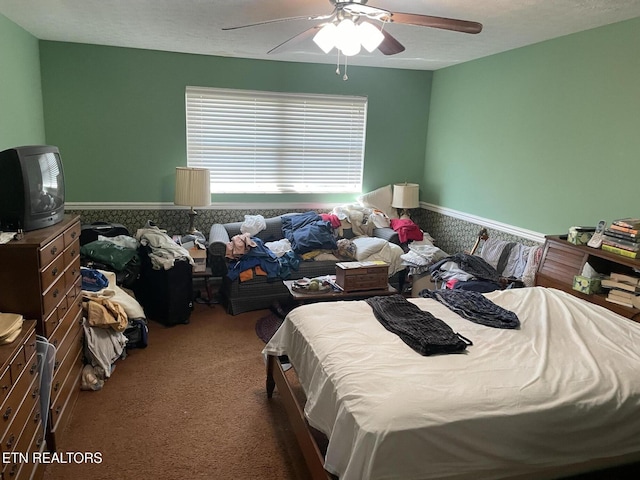 carpeted bedroom with ceiling fan and a textured ceiling