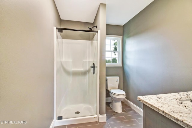 full bath featuring toilet, a stall shower, baseboards, and vanity