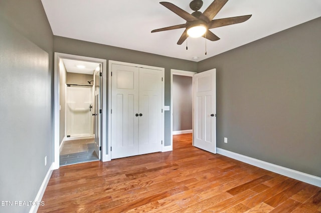 unfurnished bedroom with light wood-type flooring, baseboards, a closet, and ensuite bathroom