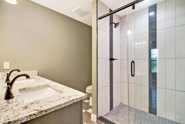 bathroom with a stall shower, visible vents, vanity, and toilet