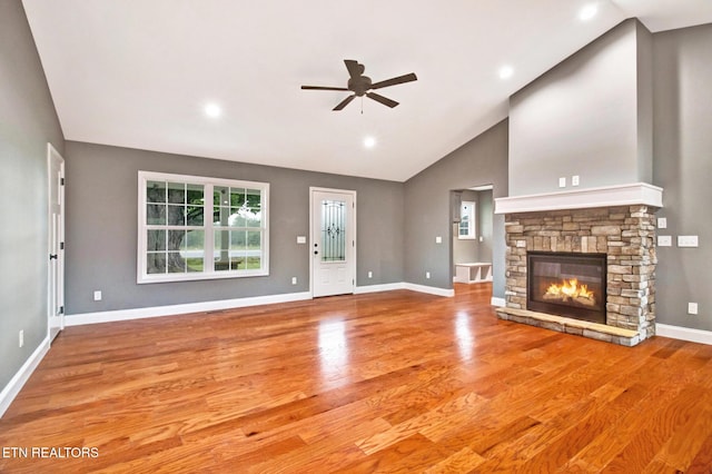 unfurnished living room with a stone fireplace, recessed lighting, wood finished floors, a ceiling fan, and baseboards