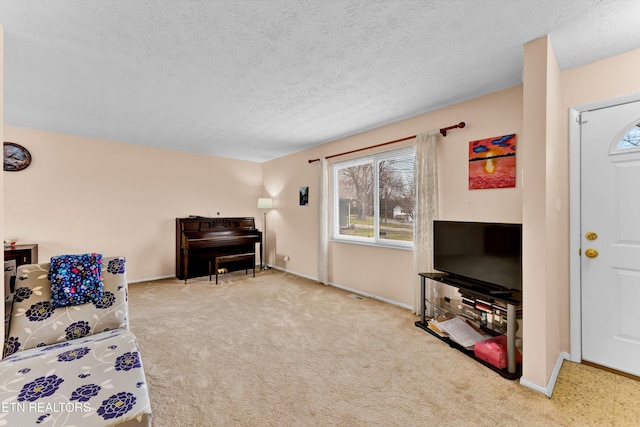 living room with carpet flooring, a textured ceiling, and baseboards