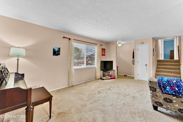 carpeted living area featuring baseboards, stairway, and a textured ceiling