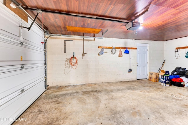 garage featuring a garage door opener and concrete block wall