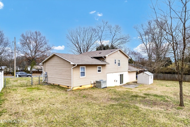 rear view of house with an outbuilding, fence, a yard, crawl space, and a shed