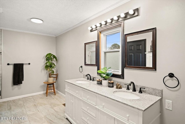 bathroom with a textured ceiling, baseboards, a sink, and crown molding