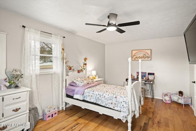 bedroom with light wood-style flooring, ceiling fan, and a textured ceiling