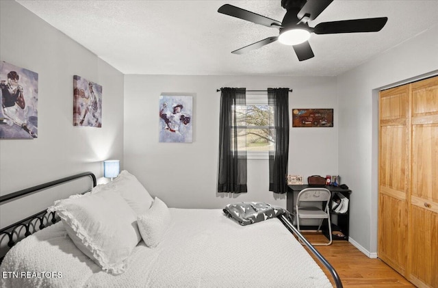 bedroom featuring a textured ceiling, ceiling fan, baseboards, and light wood-style floors