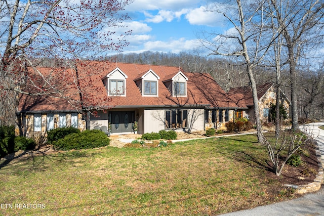 new england style home with a front lawn