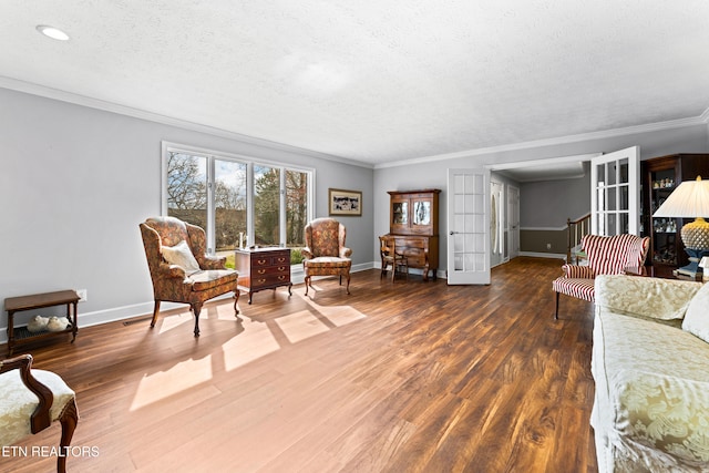 living area with baseboards, wood finished floors, and crown molding