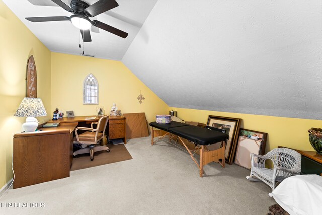 office area featuring visible vents, a ceiling fan, carpet flooring, and vaulted ceiling