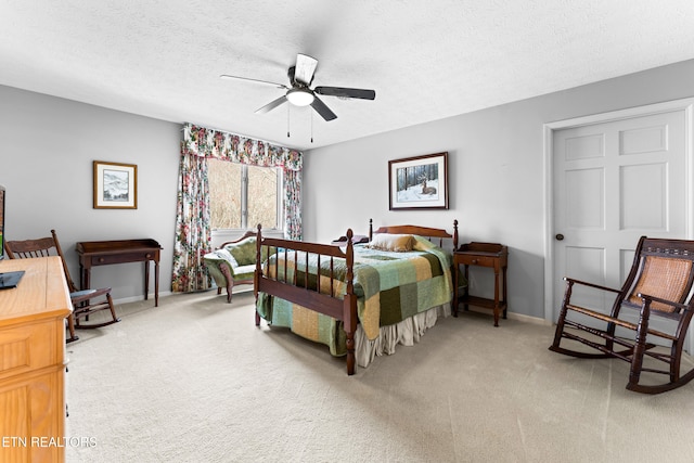 bedroom featuring ceiling fan, carpet, baseboards, and a textured ceiling