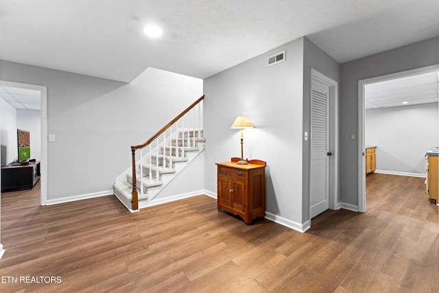 interior space with visible vents, stairs, baseboards, and wood finished floors