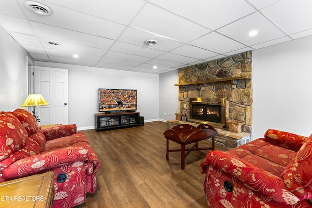 living area featuring visible vents, a fireplace, baseboards, and wood finished floors