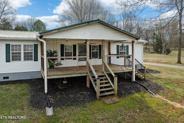 view of front of home with stairs, a front lawn, metal roof, and crawl space
